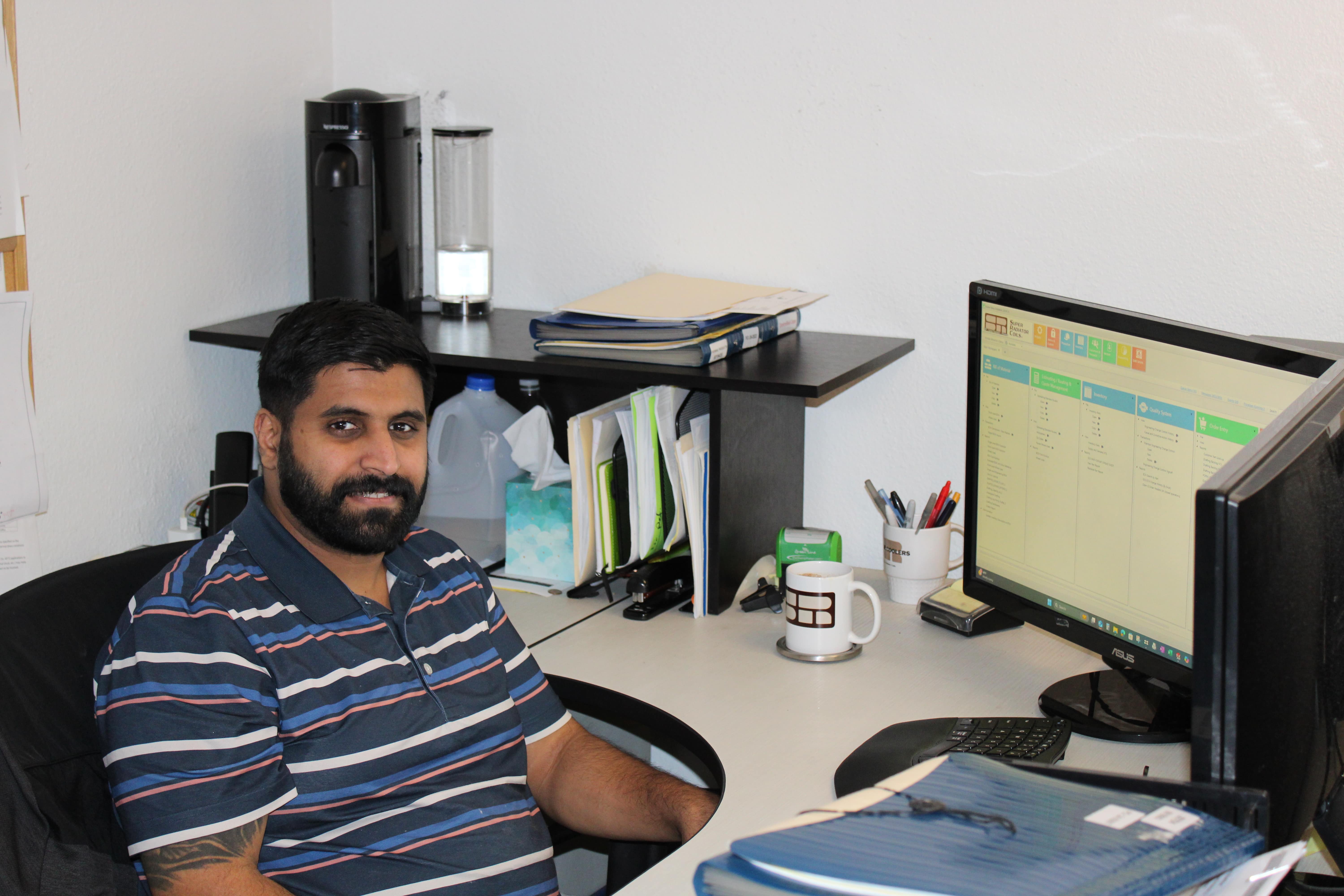 smiling man sitting at computer