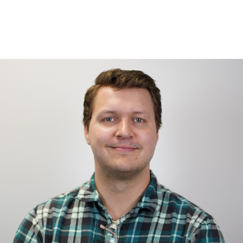 company headshot of man in green plaid shirt